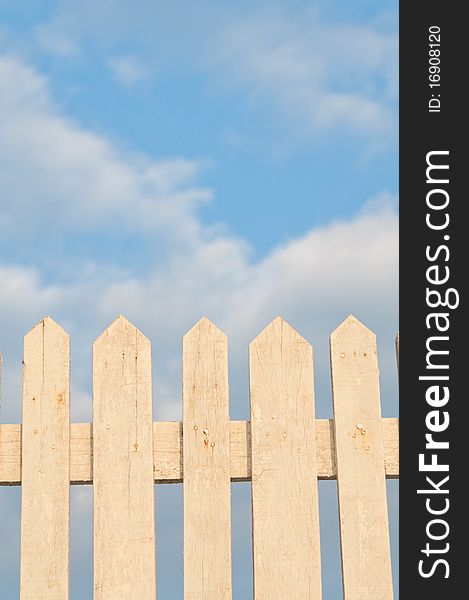 The white wooden fence with the blue sky background