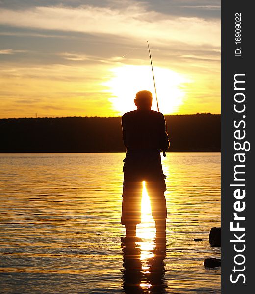 Man fishing on the coast of sea in sunset. Man fishing on the coast of sea in sunset