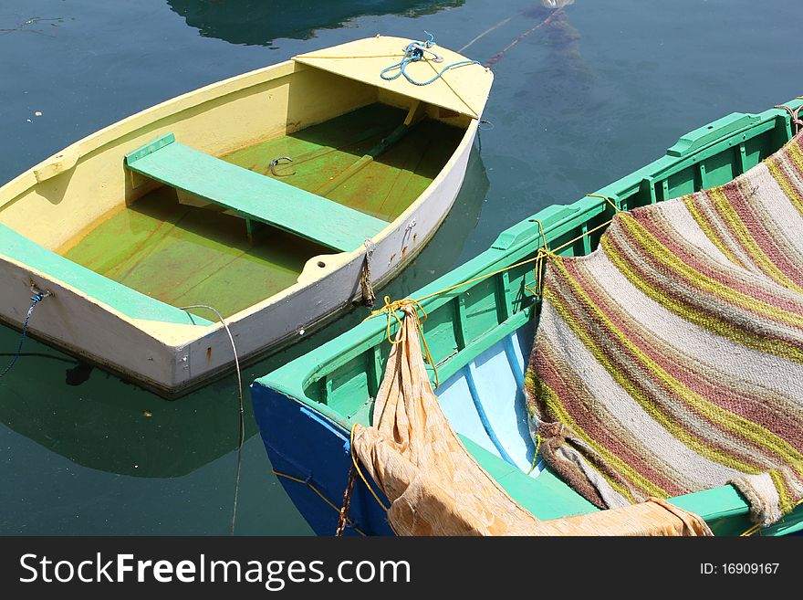 Close up of two small, brightly painted boats floating in a harbour. Close up of two small, brightly painted boats floating in a harbour.