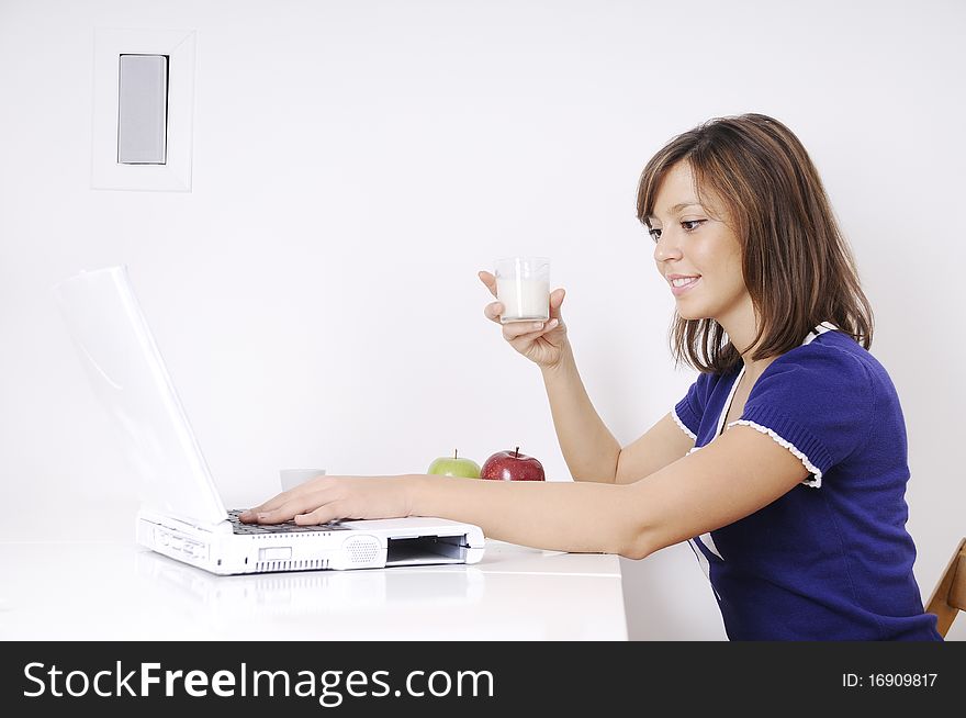 Young woman in breakfast, drinking and using laptop. Young woman in breakfast, drinking and using laptop