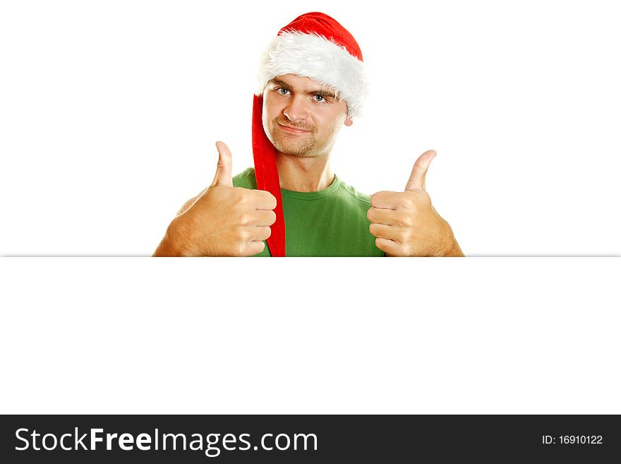 Young man in a Santa Claus hat and green poppy approvingly shows two thumbs raised up. Young man in a Santa Claus hat and green poppy approvingly shows two thumbs raised up