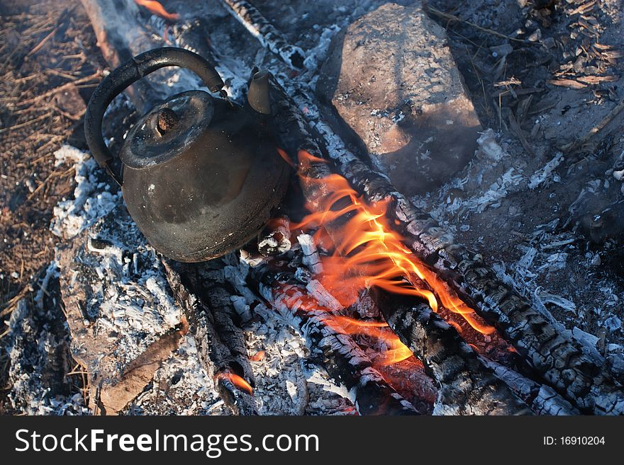 Old teapot on campfires. Rest on nature.