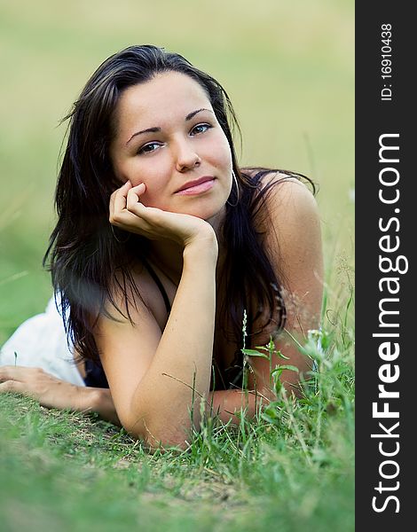 Young pretty girl lying on green grass