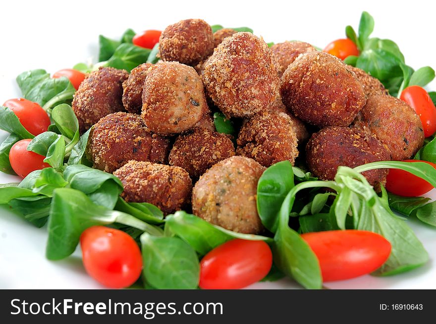 Meatballs with fresh vegetables isolated in white