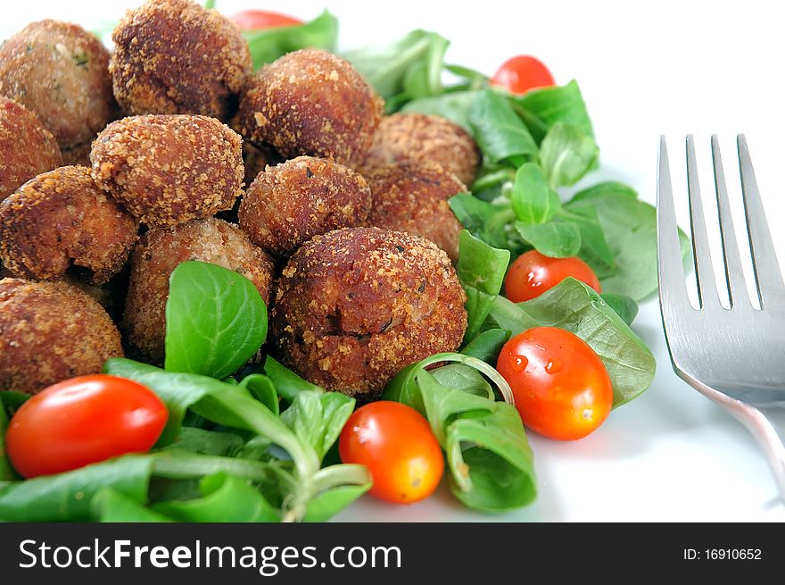 Meatballs with fresh vegetables isolated in white