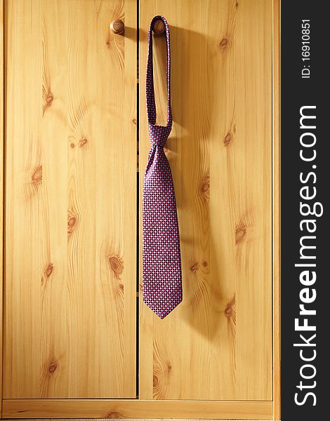 Red Striped Necktie hung from a hook wardrobe
