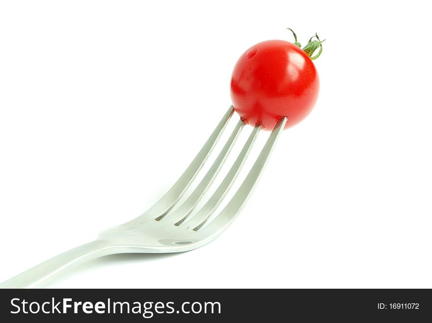 Fresh tomato on the fork on white