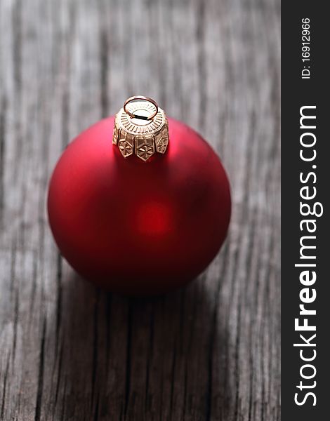 One red christmas ball on the wooden background