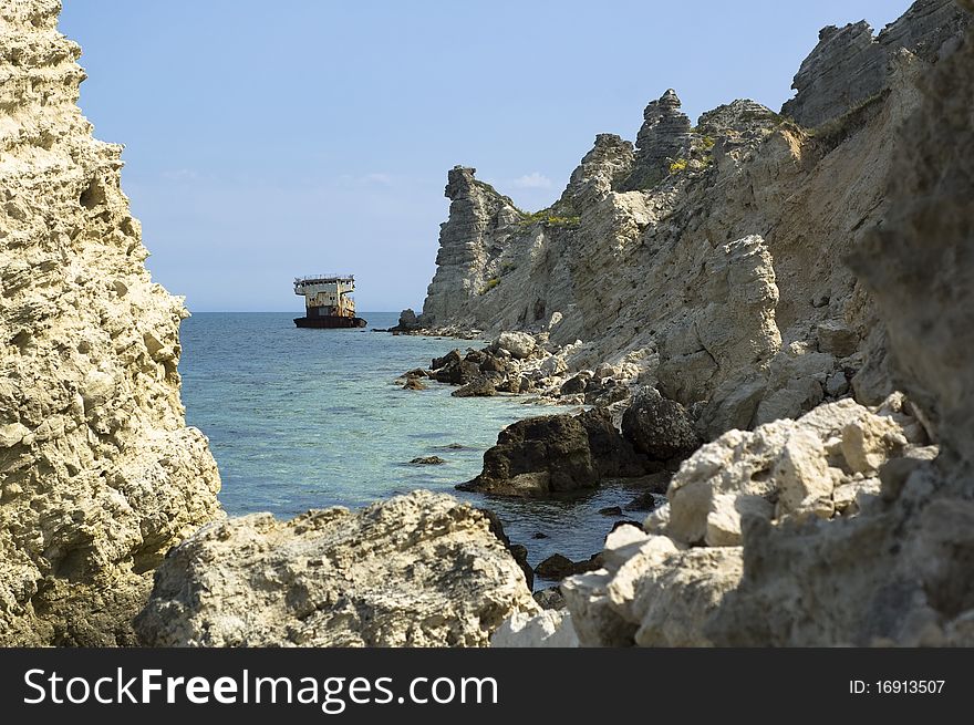 Grounded rusty ship among rocks on the seashore, Dzhangul, Tarkhankut, Crimea, Ukraine. Grounded rusty ship among rocks on the seashore, Dzhangul, Tarkhankut, Crimea, Ukraine