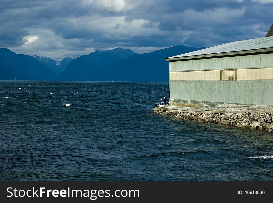 View of Sognefjord with a fisherman sitting near the building