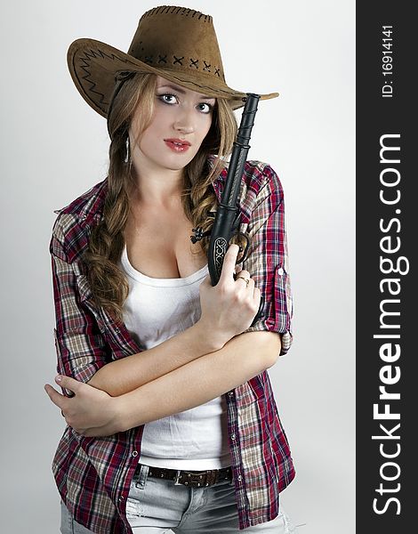 Dangerous girl holds the gun cowboy hat