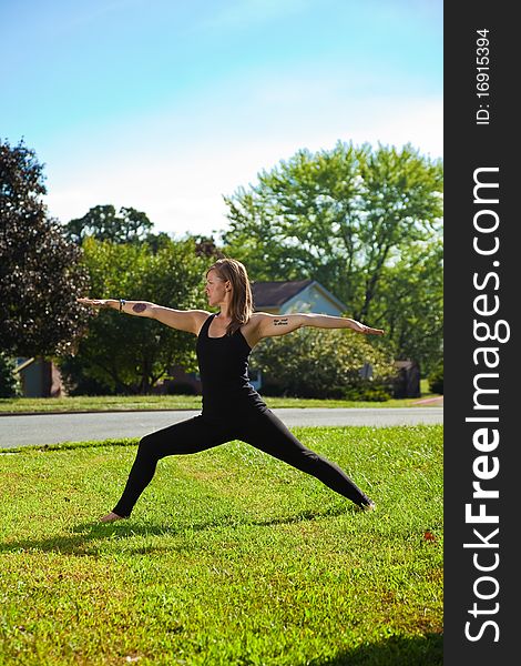 Young girl doing yoga exercise alone on the lawn