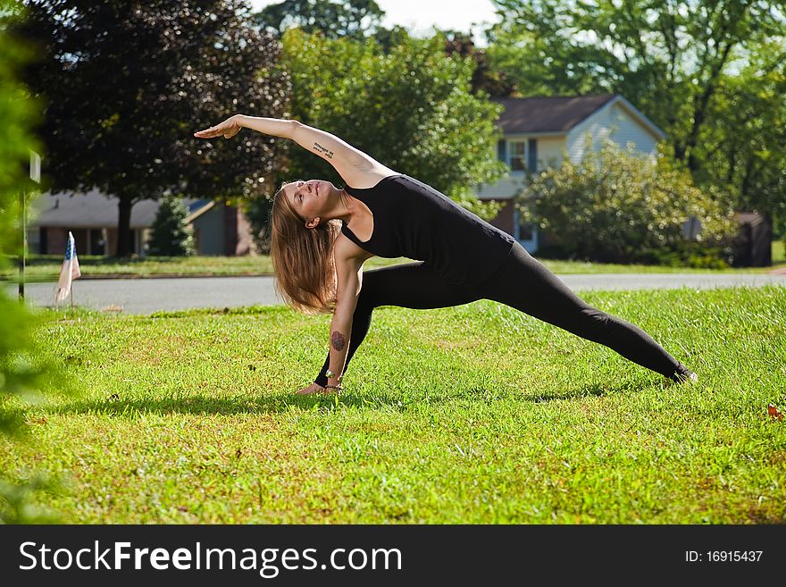 Young girl doing yoga exercise alone on the lawn