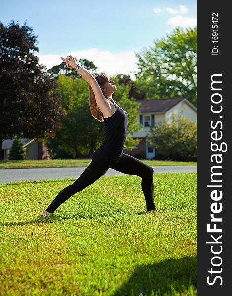 Young girl doing yoga exercise alone on the lawn