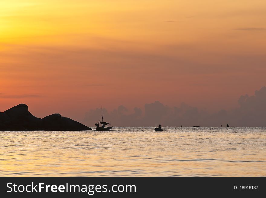 The sun is about to fall evening at sea. The island and the fishing boat to shore power. The sun is about to fall evening at sea. The island and the fishing boat to shore power