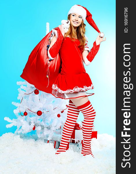 Beautiful young woman in Santa Claus clothes over Christmas background. Beautiful young woman in Santa Claus clothes over Christmas background.