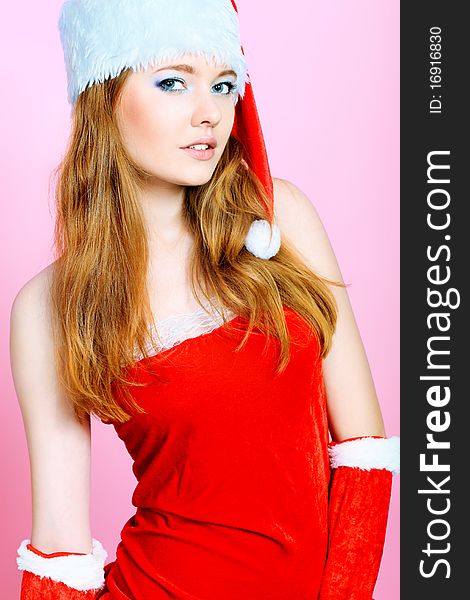 Beautiful young woman in Santa Claus clothes over Christmas background. Beautiful young woman in Santa Claus clothes over Christmas background.
