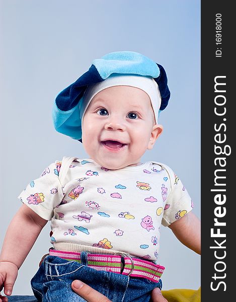 Amusing baby boy in a beret in a studio on a dark blue background