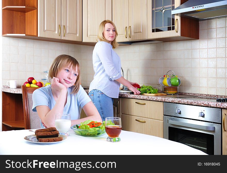 Mom and young daughter eating breakfast together in the kitchen