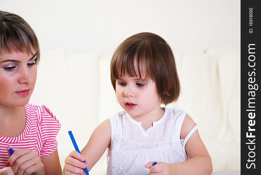 Mother and daughter together paint an album and have fun together.