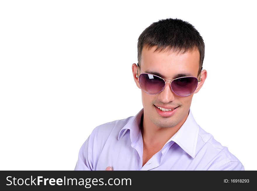 A young man in jeans and a light shirt and dark glasses