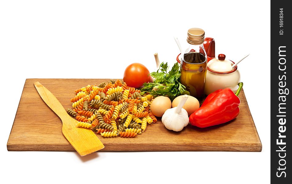 Close-up shot of spaghetti and vegetables on wooden board. Studio shot