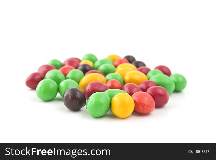 Pills with peanuts covered with multicolored glaze on a white background