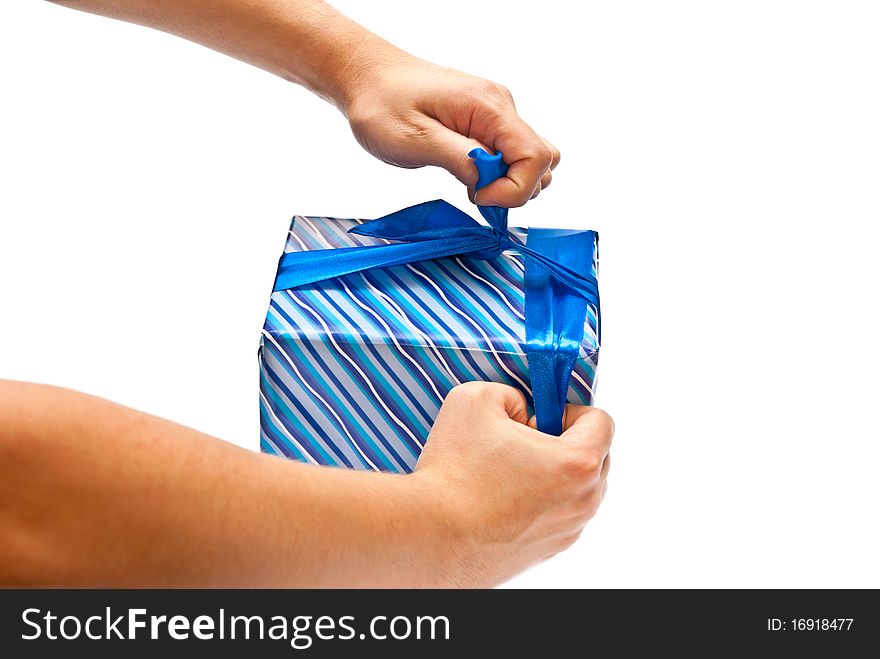 Isolated man's hands opening blue present. White background. Isolated man's hands opening blue present. White background