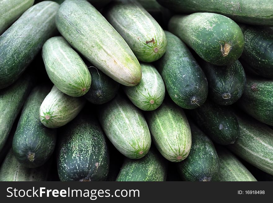 Photo of stack up cucumbers at market