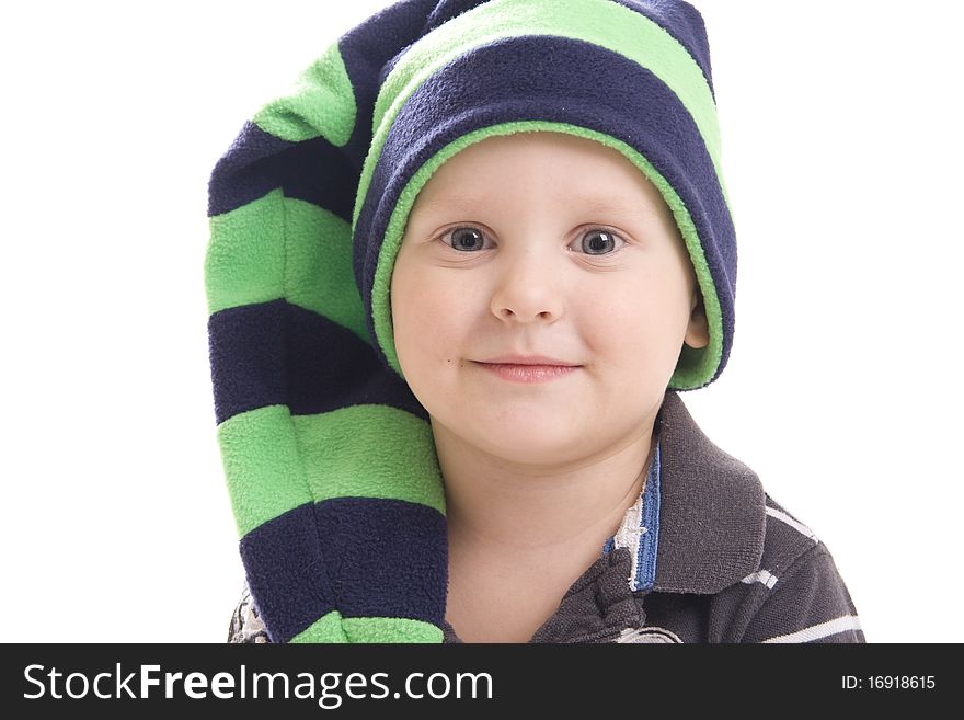 Boy in a green cap is smiling looking directly on a white background. Boy in a green cap is smiling looking directly on a white background