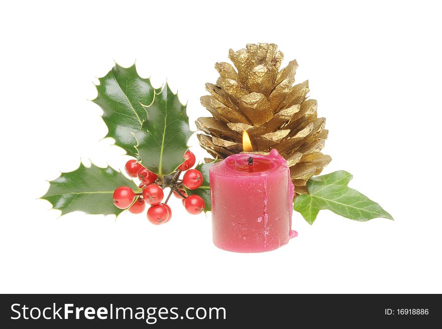 Christmas decoration with,holly,ivy, golden pine cone and a burning candle