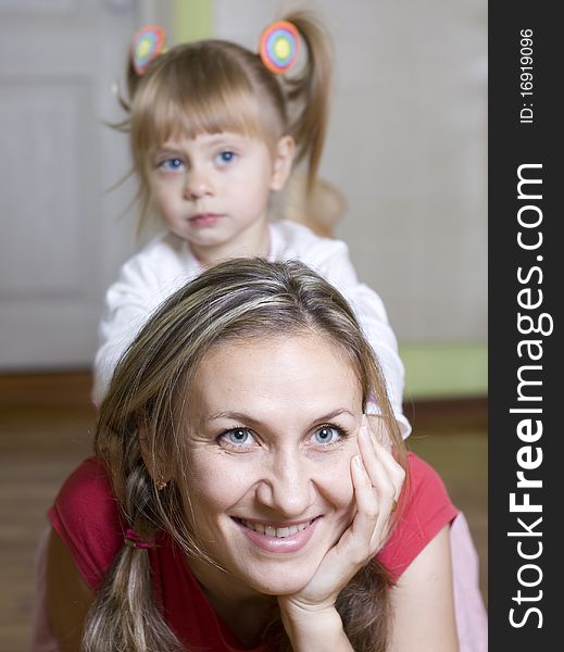 Happy mom plays with her daughter at home