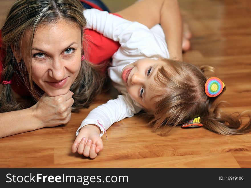 Happy mom plays with her daughter at home