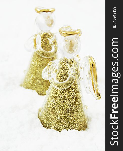 Golden glass angels in snow, decoration for Christmas