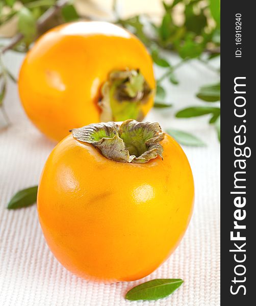 Two kaki fruits ( persimmon) on table