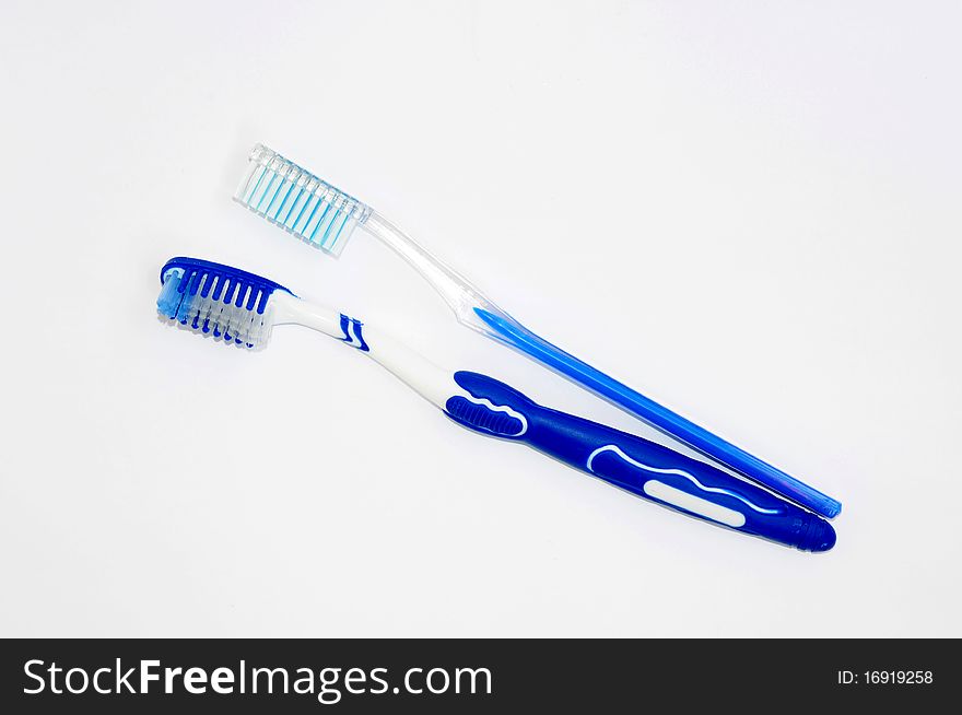 Pair of blue toothbrushes isolated on a white background. Pair of blue toothbrushes isolated on a white background.