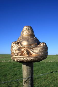 A Golden Buddha Sitting On The Fence Stock Image