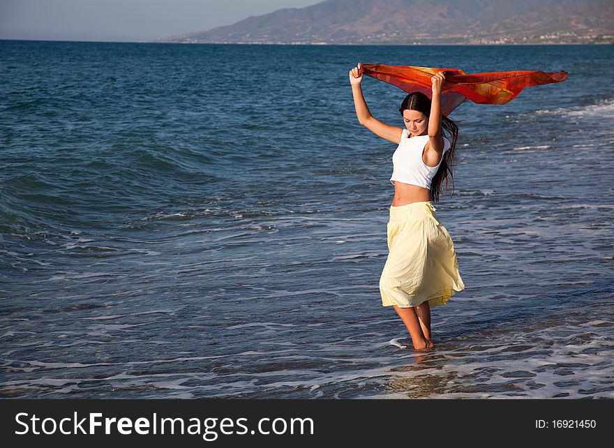 A young woman with the pareo is on a coast