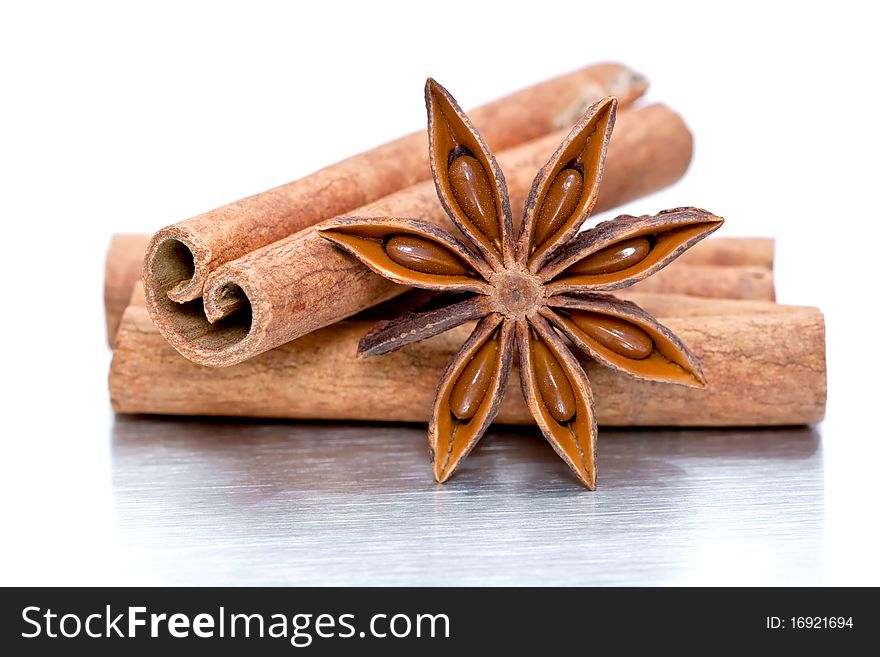 Cinnamon sticks and star anise on grey brushed metal background