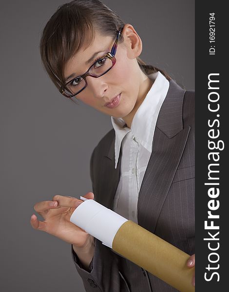 Portrait of business woman holding blueprints over grey background. Portrait of business woman holding blueprints over grey background