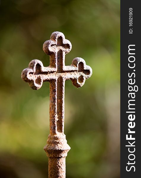 Rusty cross against green background