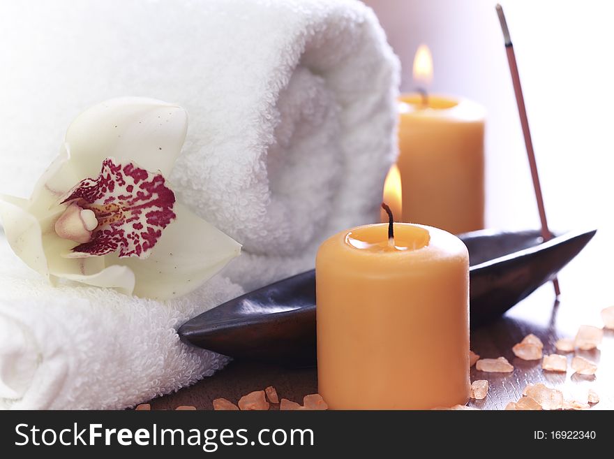 Spa setting with burning towel, candles and salt