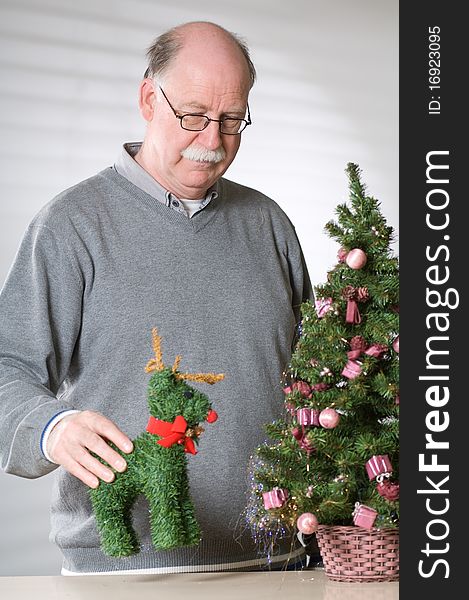 Senior man with christmas decoration on white