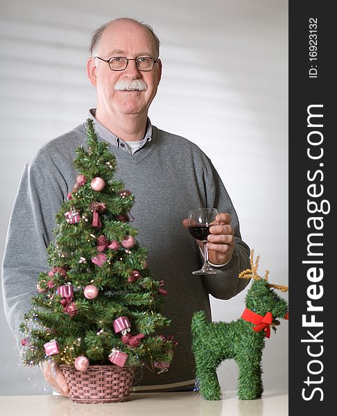 Senior man with christmas decoration on white