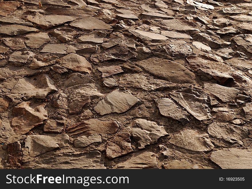 Rough texture of wet block old pavement.