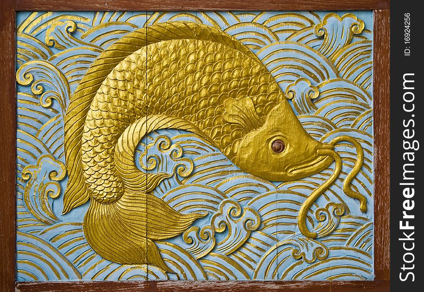 Fish carve gold paint in temple wall
