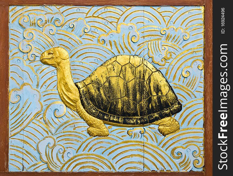 Turtle carve gold paint in temple wall