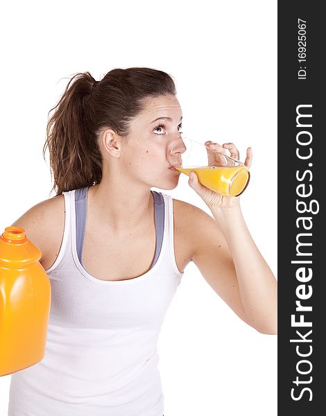 A woman in fitness attire is drinking orange juice. A woman in fitness attire is drinking orange juice.