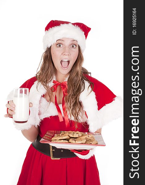 A young mrs Santa is holding a glass of milk and a plate of cookies. A young mrs Santa is holding a glass of milk and a plate of cookies.