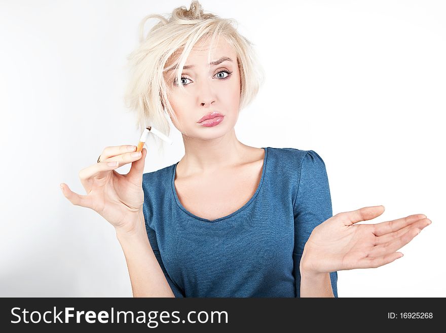 Worried blond lady holding a broken cigarette